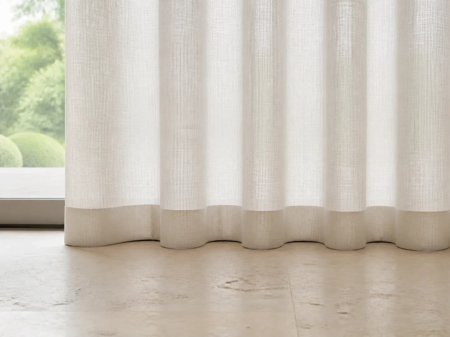 Level weighted ivory sheer curtain hem touching the floor evenly